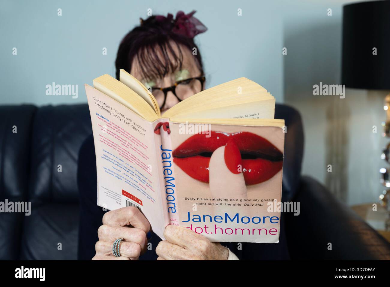 Frau liest Dot.homme von Jame Moore Stockfoto