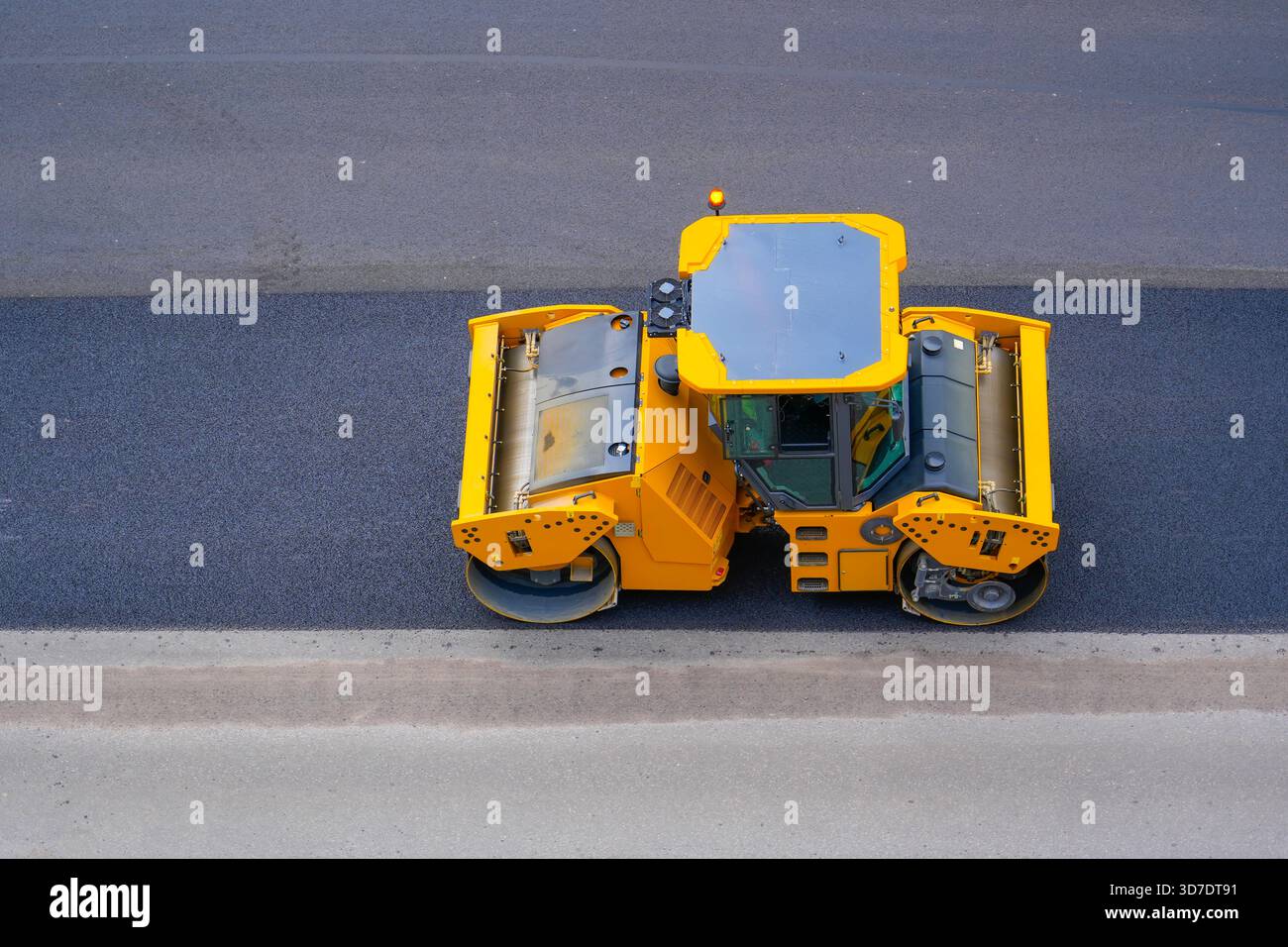 Straßenreparatur Straßenwalze gelbe Maschine rollt Asphalt Stadtstraße, Luftaufnahme. Stockfoto