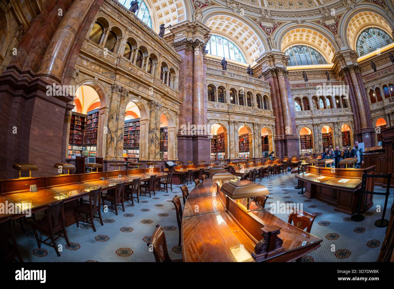 WASHINGTON DC – der Hauptsaal des Library of Congress Jefferson Building verfügt über eine herrliche Kuppeldecke und halbkreisförmige Buntglasfenster. Diese Fenster zeigen das große Siegel der Vereinigten Staaten und die Siegel der achtundvierzig staaten und Territorien aus dem Bau des Gebäudes. Das literarische Design des Raumes beinhaltet Nachnamen von zehn großen Autoren, wie Shakespeare, Dante und Homer, die auf Deckentabletten eingeschrieben sind. Weitere Autoren, darunter amerikanische Autoren, werden in der ganzen Halle geehrt. Dieser große Raum wird oft als „Buchpalast des Amerikaners“ bezeichnet Stockfoto