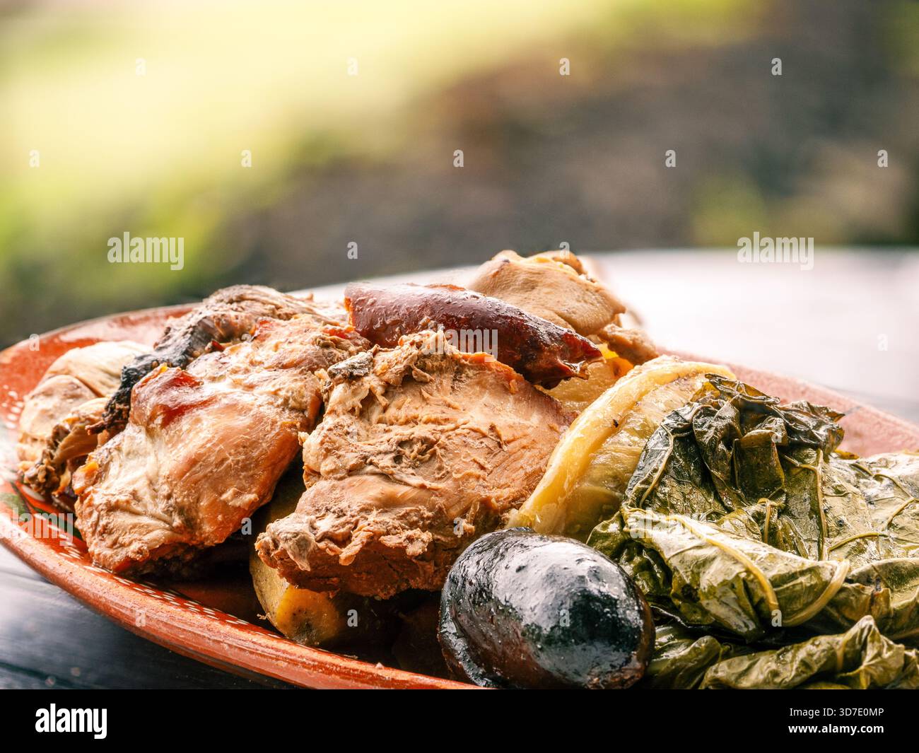Traditioneller portugiesischer Fleischeintopf Cozido das Furnas, serviert auf einem rustikalen Teller, der in vulkanischer Hitze auf der Insel São Miguel auf den Azoren zubereitet wird. Ideal für Essen, TRA Stockfoto