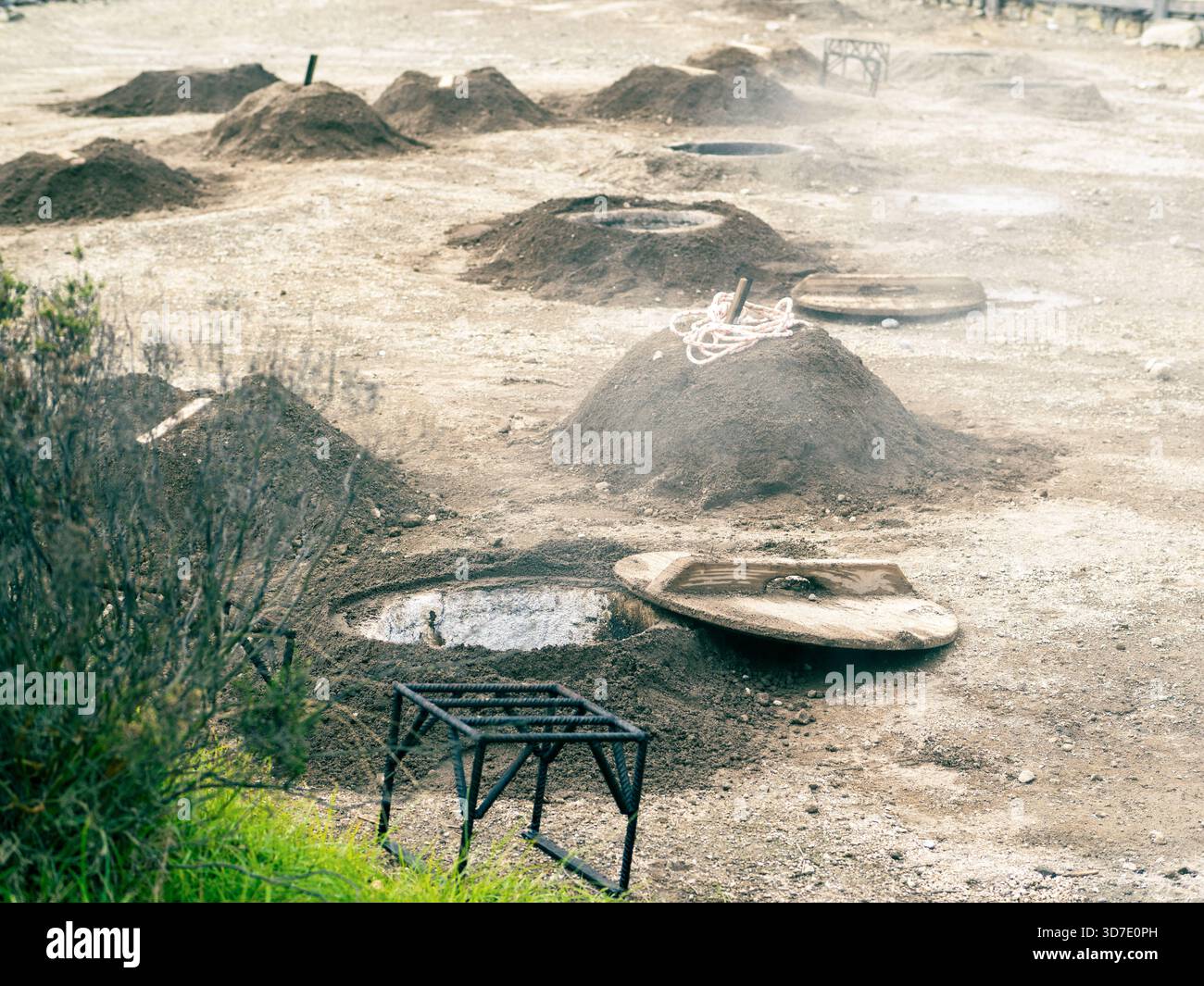 Vulkanische Dampfgruben zum Kochen von Cozido das Furnas in São Miguel auf den Azoren. Überdachte Kochlöcher in heißem Boden, Teil der geothermischen Nahrung der Insel Stockfoto