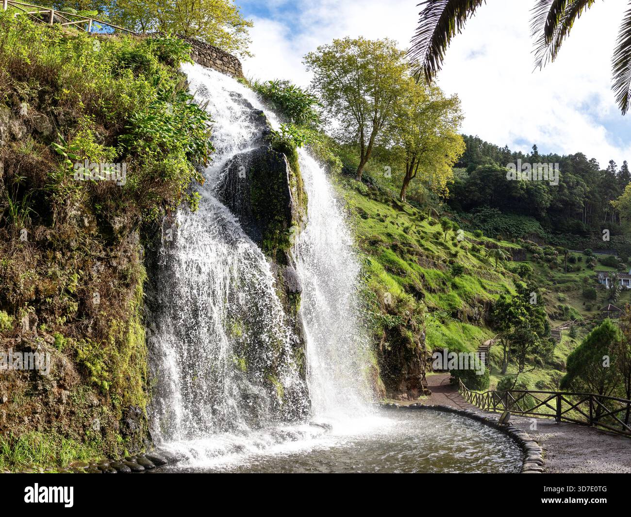Malerischer Wasserfall im Naturpark Ribeira dos Caldeirões auf der Insel São Miguel, Azoren, Portugal – umgeben von üppiger Vegetation und Wanderwegen. Stockfoto
