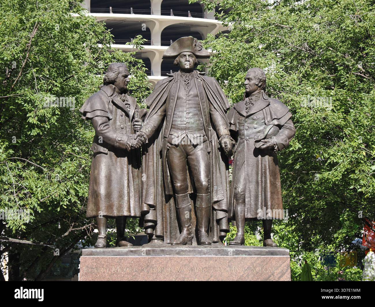 Chicago, Illinois – 18. September 2025: Die Bronzeskulptur „The Alarm“ von Washington, Lafayette und Hamilton gegen einen grünen Baum und Parkhaus zurück Stockfoto