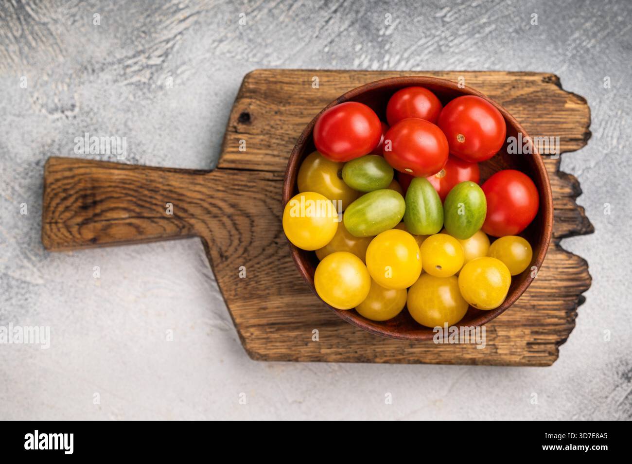Frische kleine rote, grüne und gelbe Kirschtomaten-Sortiment, Mini-Bio-Cocktail-Tomatenmischung. Weißer Hintergrund. Draufsicht. Stockfoto