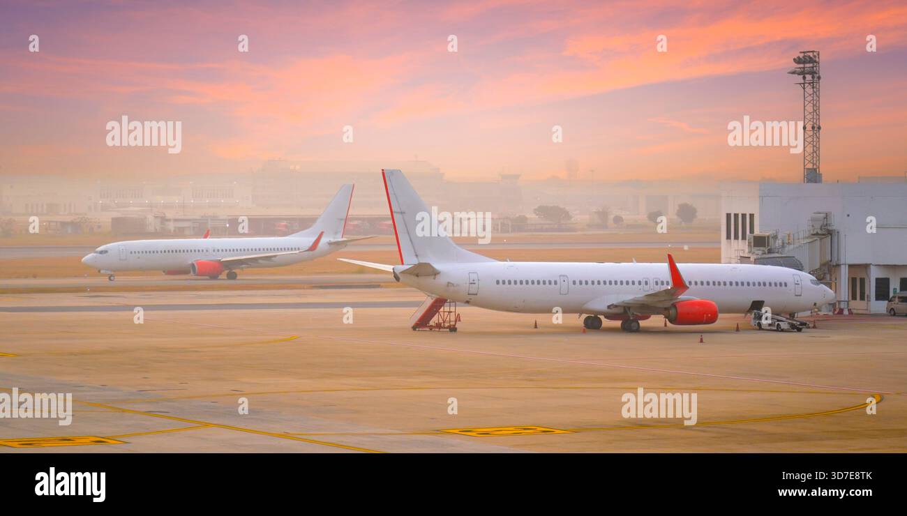 Kommerzielles Passagierflugzeug während der Taxibewegung für den Start und ein anderer Passagier für den Flug am frühen Morgen. Stockfoto