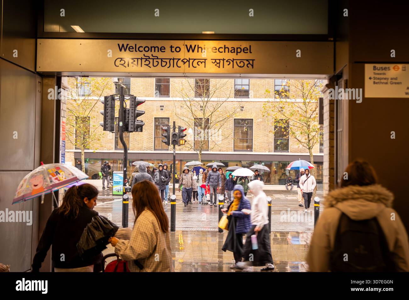 LONDON – 29. OKTOBER 2025: Whitechapel Station E1 – Pendler mit Regenschirmen fahren an regnerischen Herbsttagen aus Stockfoto