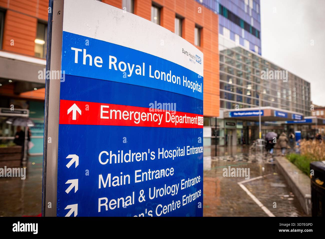 LONDON - 29. OKTOBER 2025: Royal London Hospital E1 – moderner blauer Glasturm und Eingang des Frauenzentrums an regnerischen Tagen Stockfoto