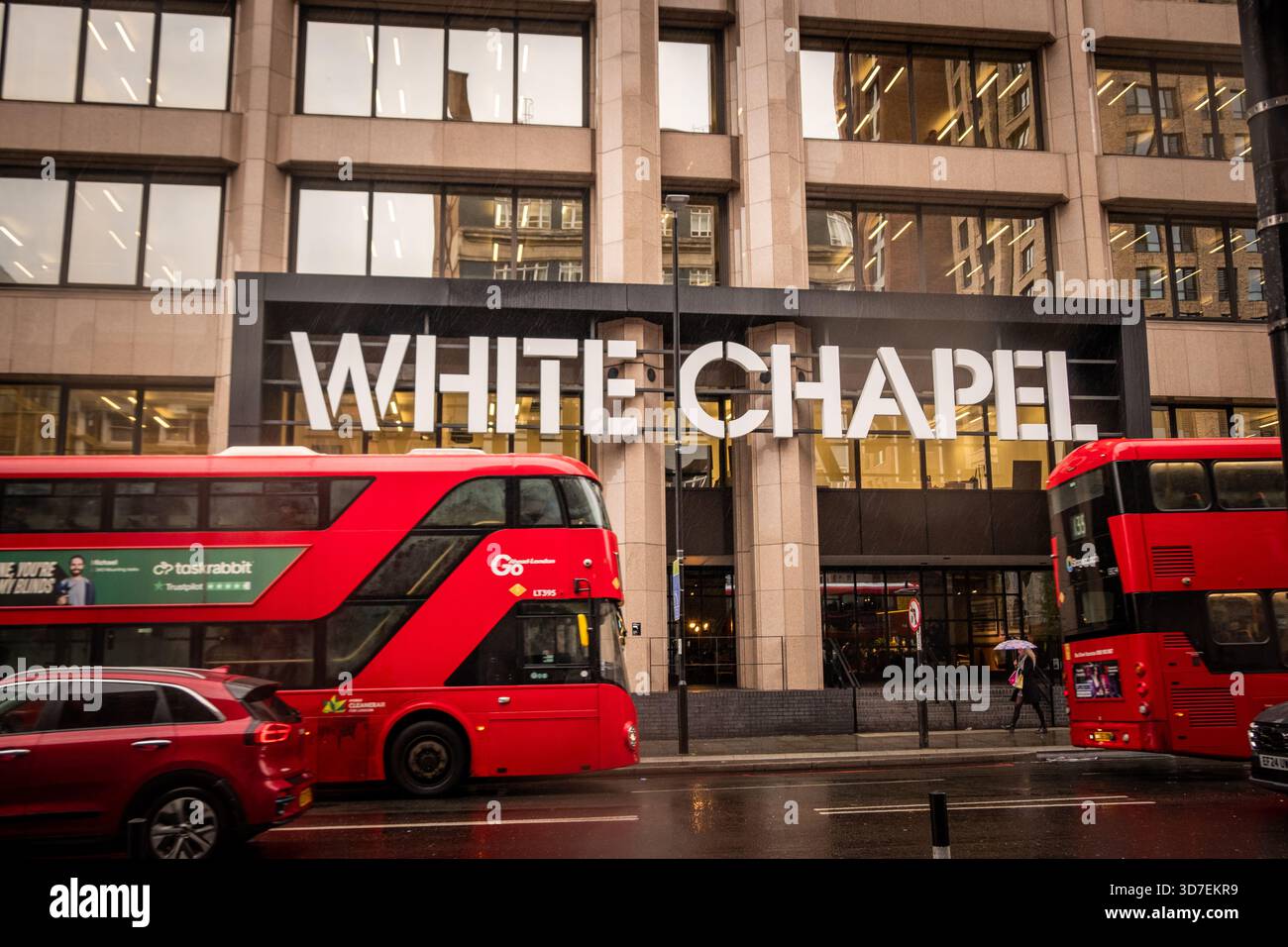 LONDON - 29. OKTOBER 2025: Whitechapel - Whitechapel Building mit roten Doppeldeckerbussen an regnerischen Tagen Stockfoto
