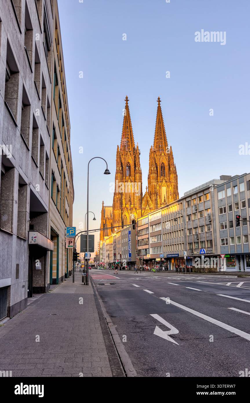 Kölner Dom, beleuchtet in der Abenddämmerung, Blick von einer ruhigen Straße in Köln, Deutschland. Stockfoto