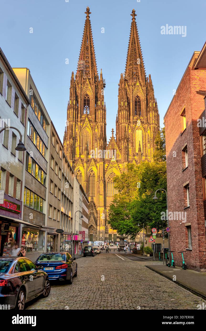 Kölner Dom, beleuchtet in der Abenddämmerung, Blick von einer ruhigen Straße in Köln, Deutschland. Stockfoto