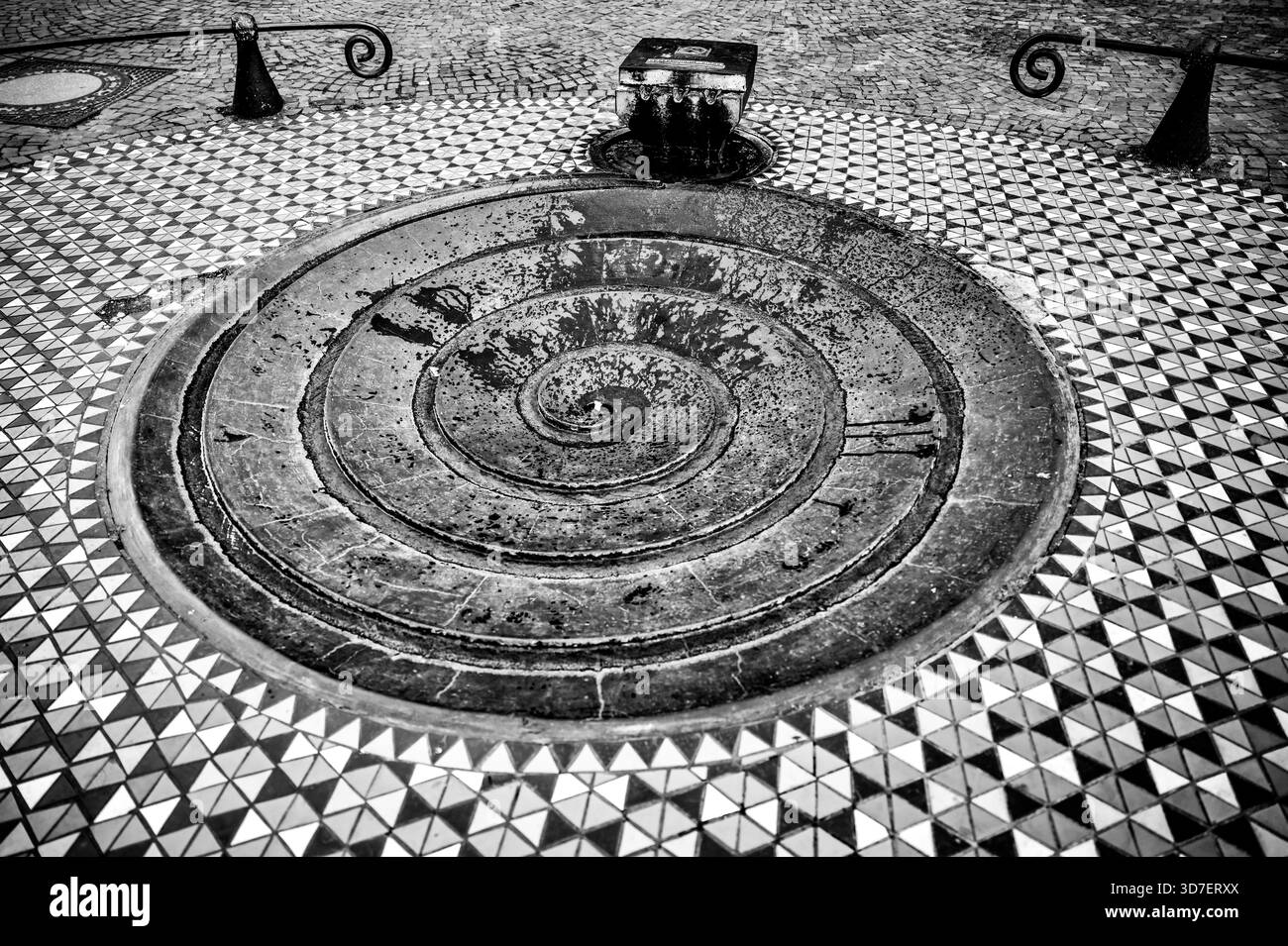 Spiralförmiger Steinbrunnen und Wasserspiel in gemustertem Pflaster in der Nähe des Kölner Doms in Köln, Deutschland. Stockfoto