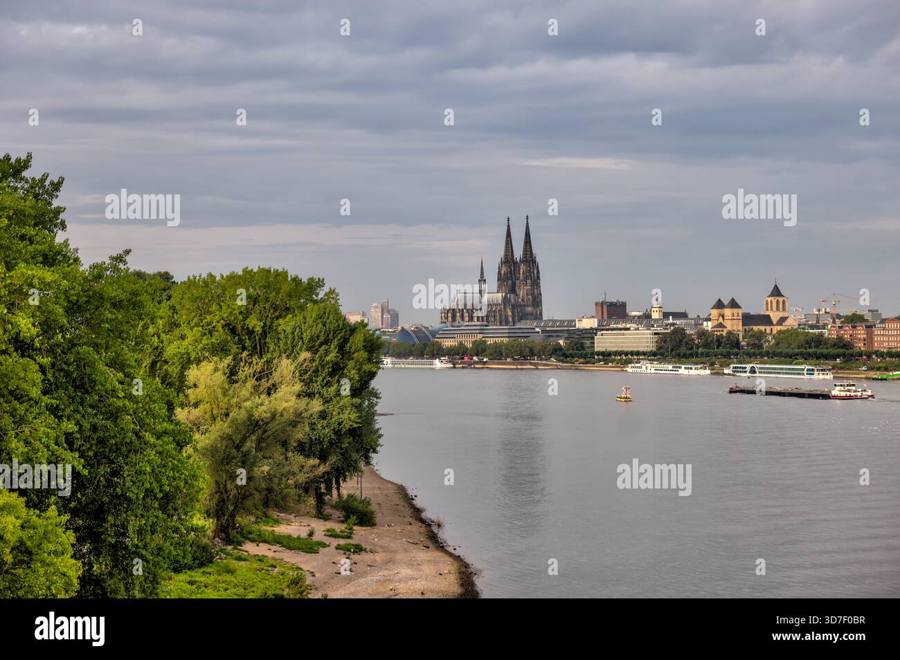 Breiter Blick auf den Rhein in Richtung Kölner Dom und Skyline der Stadt unter weichen Morgenwolken. Stockfoto