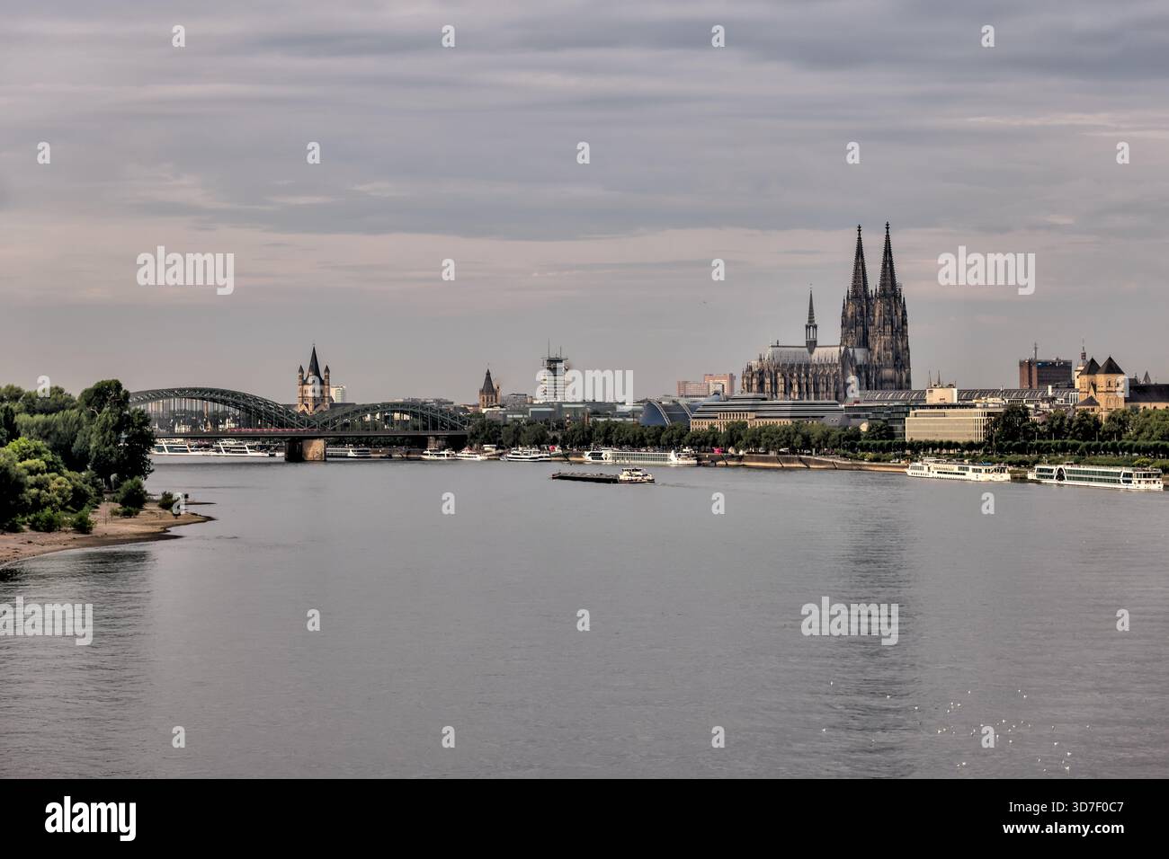 Breiter Blick auf den Rhein in Richtung Kölner Dom und Skyline der Stadt unter weichen Morgenwolken. Stockfoto