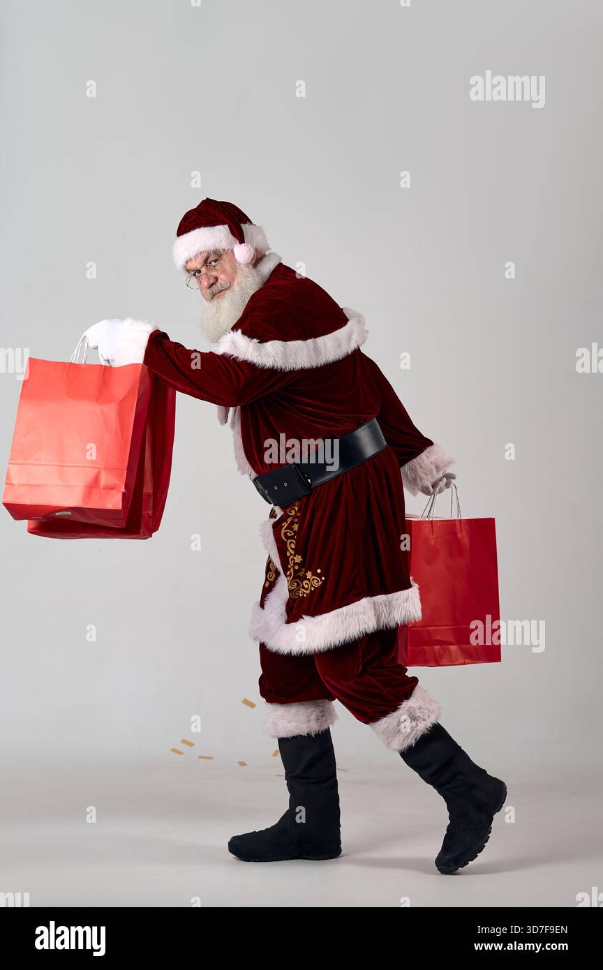 Ein Porträt des Weihnachtsmanns mit roten Paketen auf weißem Hintergrund Stockfoto