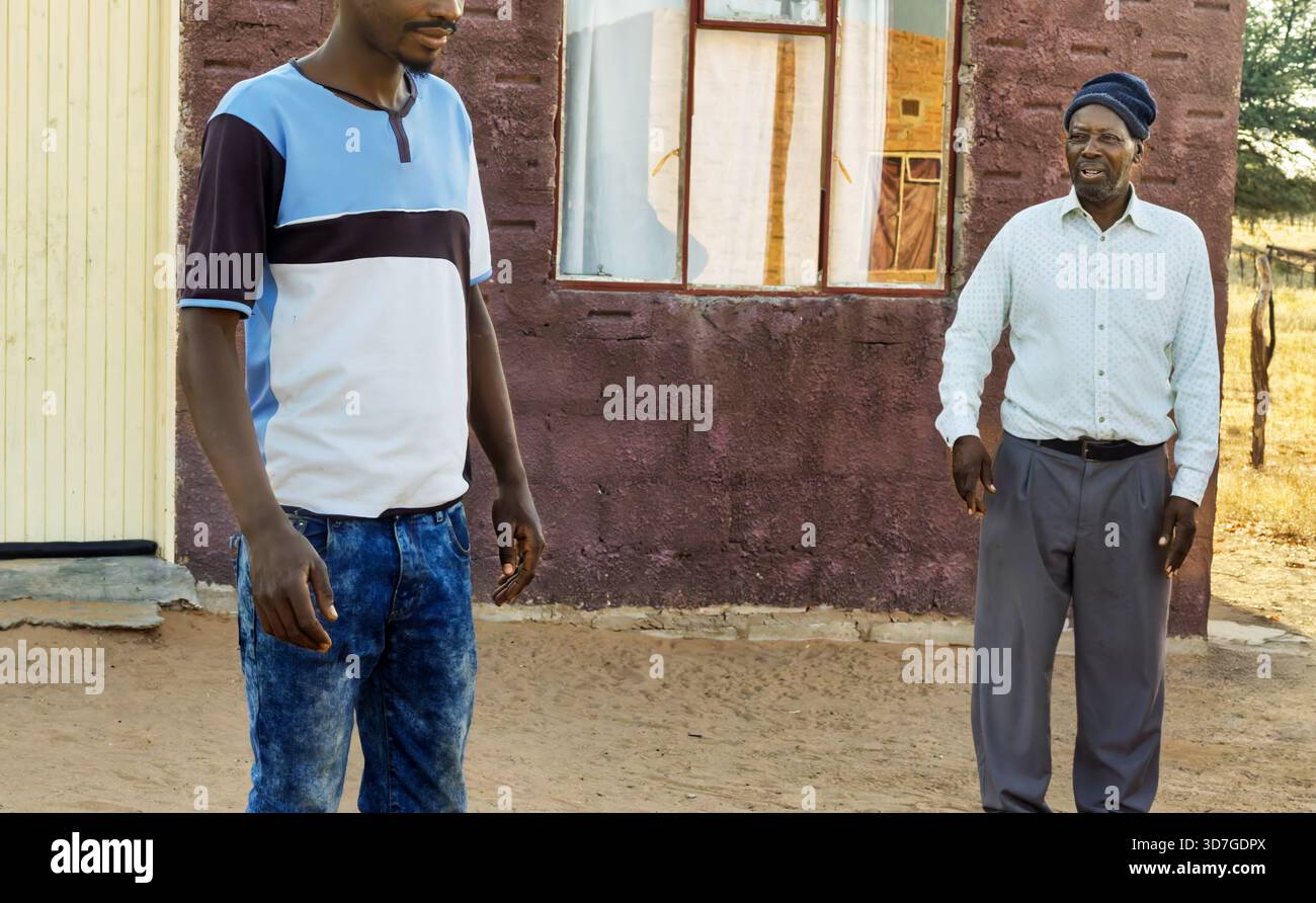 Dorf zwei afrikanische Männer vor dem Haus im Hof, Sandboden, morgens Stockfoto