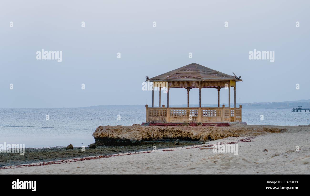 Ein Pavillon am Meer steht auf einem Korallenfelsen in einem ägyptischen Resort mit Blick auf das ruhige Morgenmeer. Stockfoto
