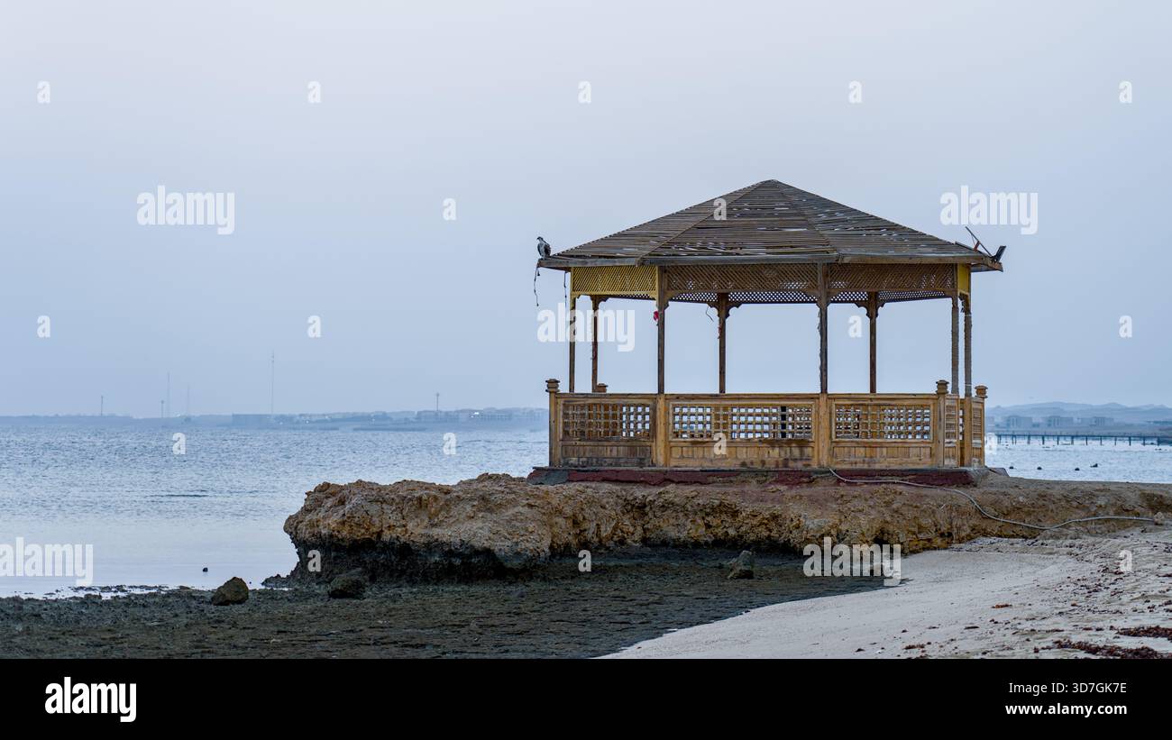 Ein Pavillon am Meer steht auf einem Korallenfelsen in einem ägyptischen Resort mit Blick auf das ruhige Morgenmeer. Stockfoto