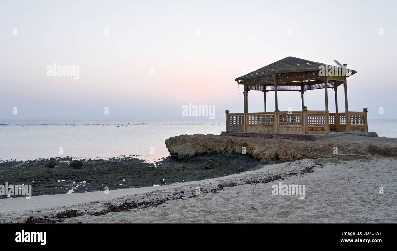 Ein Pavillon am Meer steht auf einem Korallenfelsen in einem ägyptischen Resort mit Blick auf das ruhige Morgenmeer. Stockfoto
