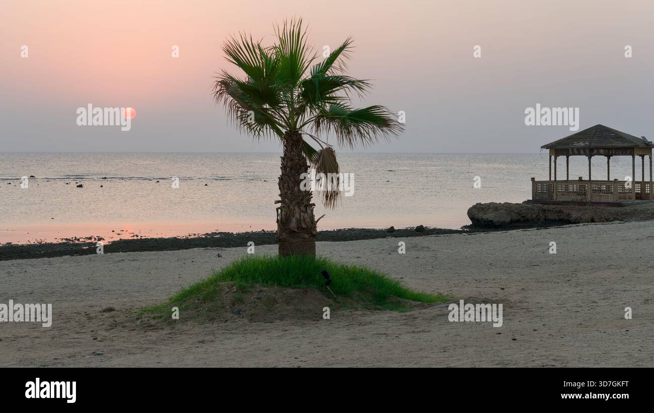 Sonnenaufgang über der Küste des Roten Meeres in einem ägyptischen Hotelresort, warmes Licht über die ruhige Küstenlandschaft. Stockfoto