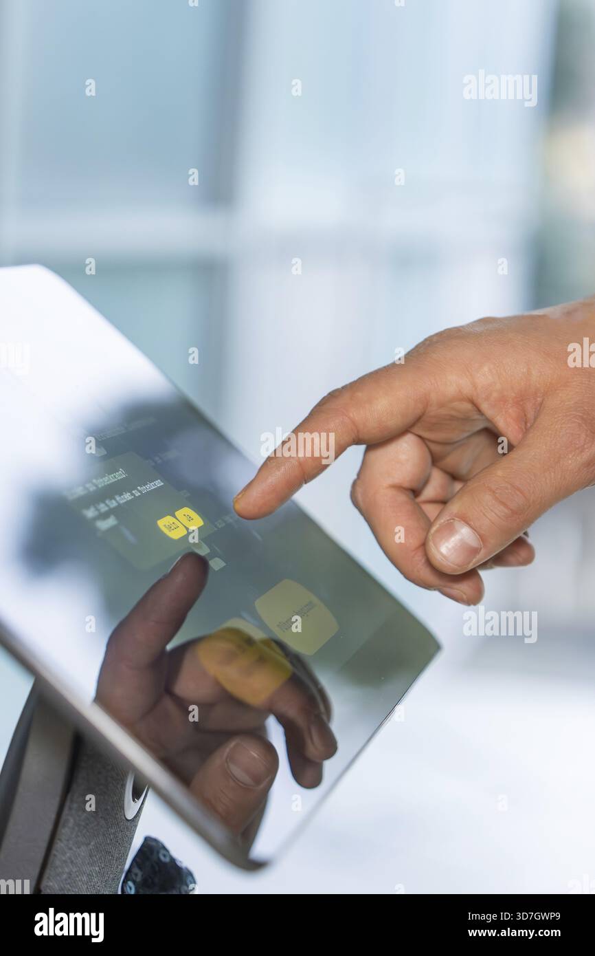 Nahaufnahme einer Hand, die einen Touchscreen mit reflektierendem Display berührt, RoboterpersönlichkeitsRoboloutionen im Schmuckmuseum Pforzheim, Deutschland Stockfoto