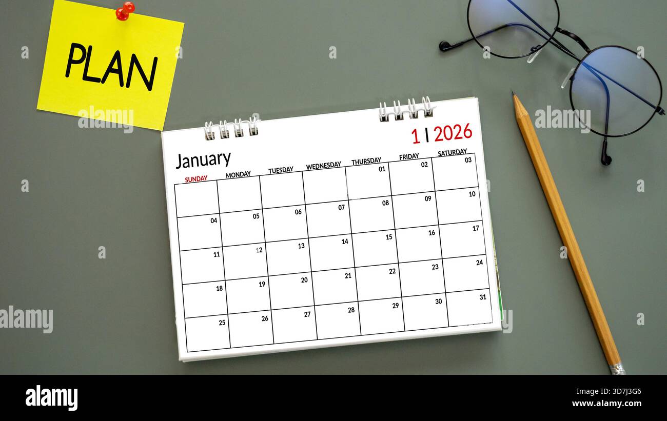 Neujahrskalender 2026, Januar mit Wortplan auf Post-it Papiernadel auf grünem Hintergrund, Bleistift und Brille daneben. Symbolisieren Neujahrsziele, Stockfoto