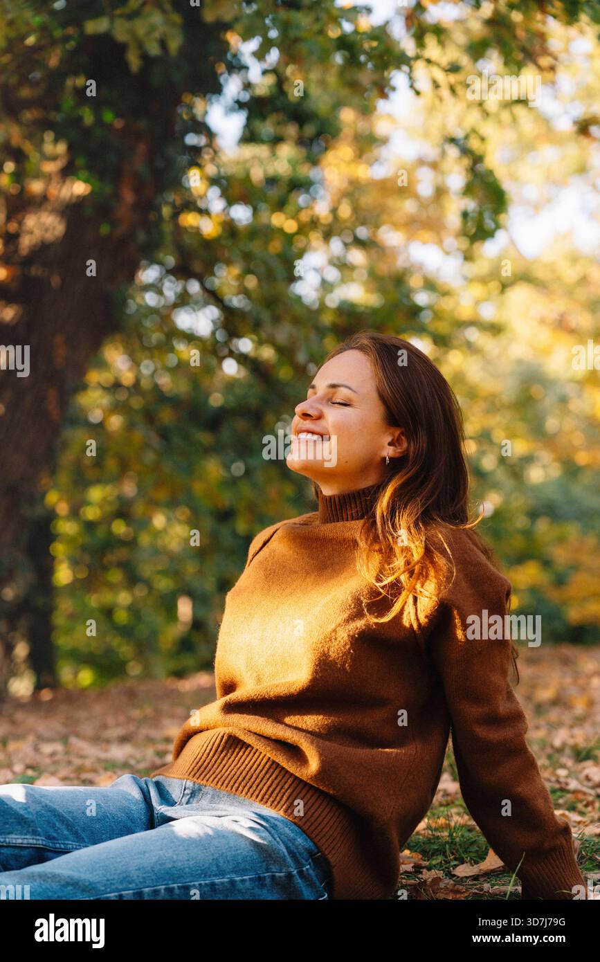 Entspannte Frau, die einen friedlichen Herbsttag im Freien genießt Stockfoto