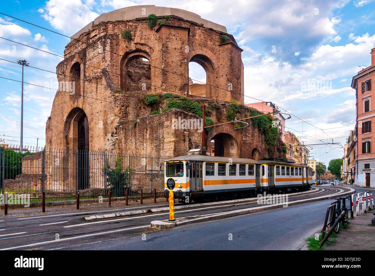 Ein Zug der Bahnstrecke Roma–Giardinetti fährt am Tempel der Minerva Medica in Rom, Italien, vorbei. Stockfoto