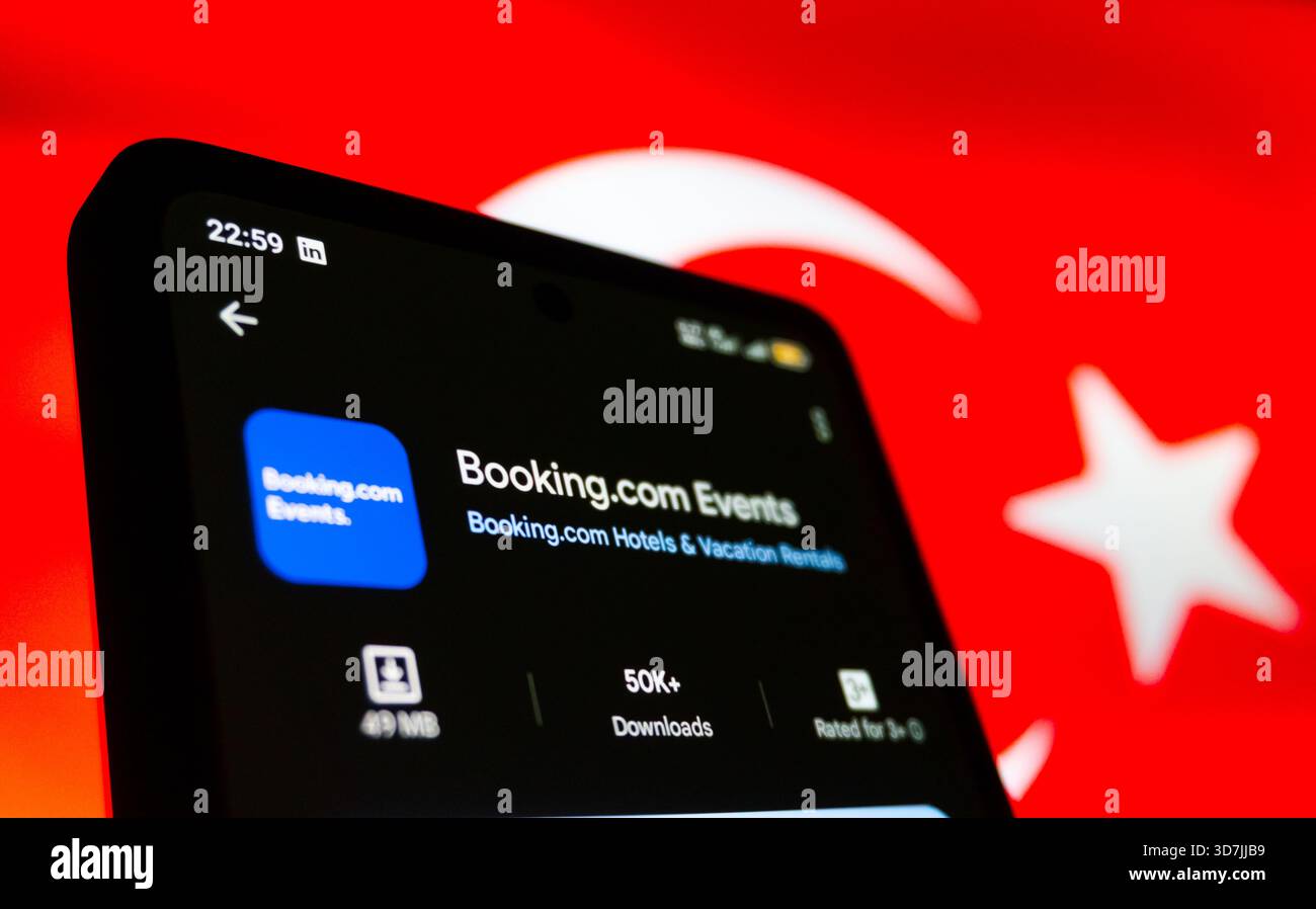 Booking.com Events App auf dem Smartphone-Bildschirm mit dem Hintergrund der Turkiye-Flagge. Baku, Aserbaidschan. 11.26.2025. Stockfoto