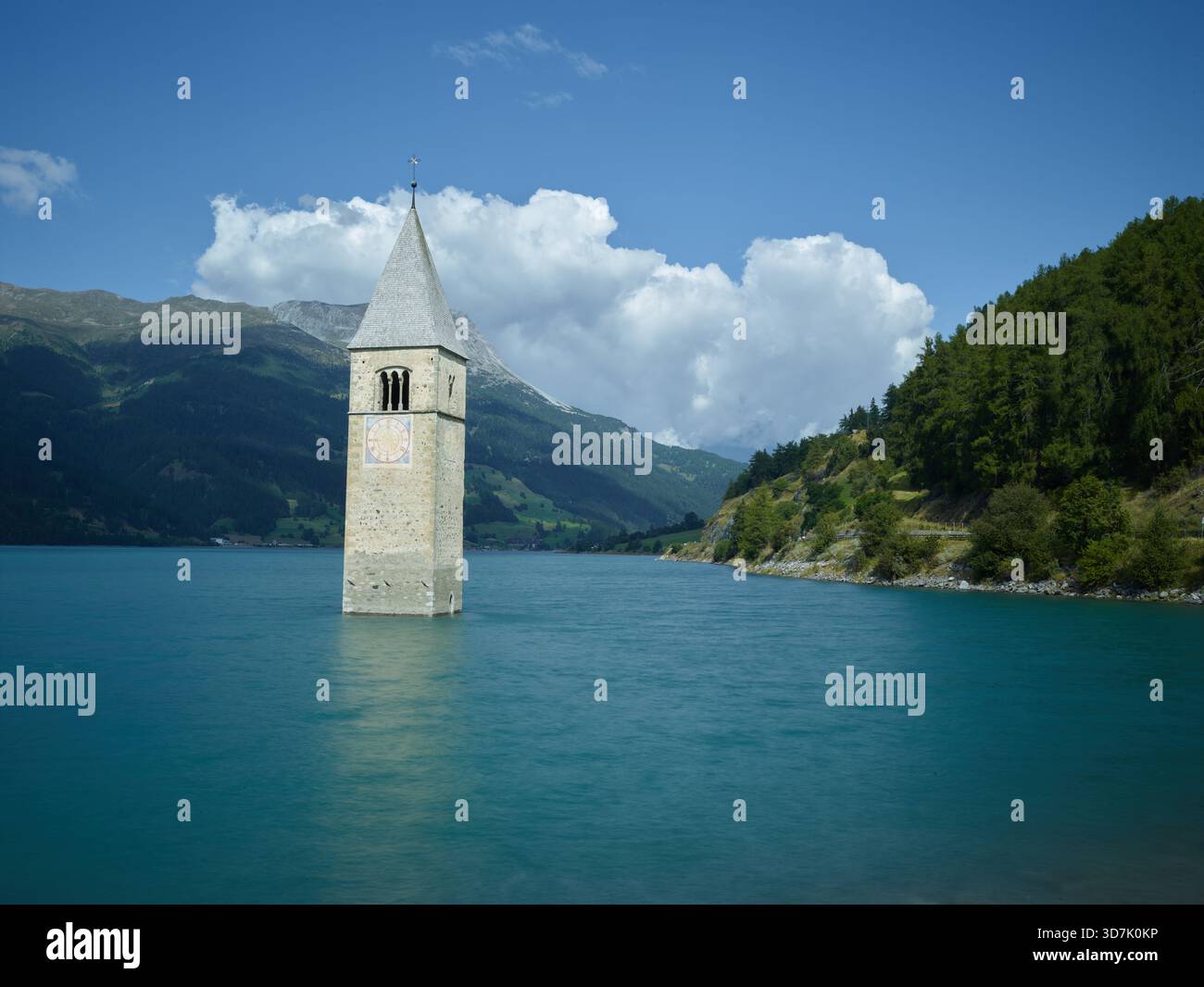 Italien, Bozen, Reschensee, verschlungener Kirchturm, der aus den Gewässern des Sees, umgeben von Bergen, entspringt Stockfoto