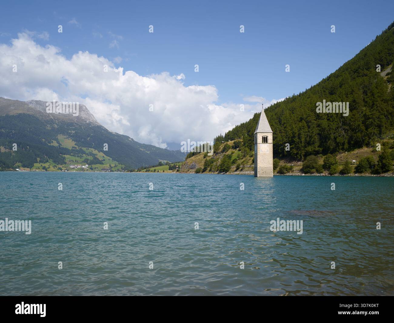 Italien, Bozen, Reschensee, verschlungener Kirchturm, der aus den Gewässern des Sees, umgeben von Bergen, entspringt Stockfoto