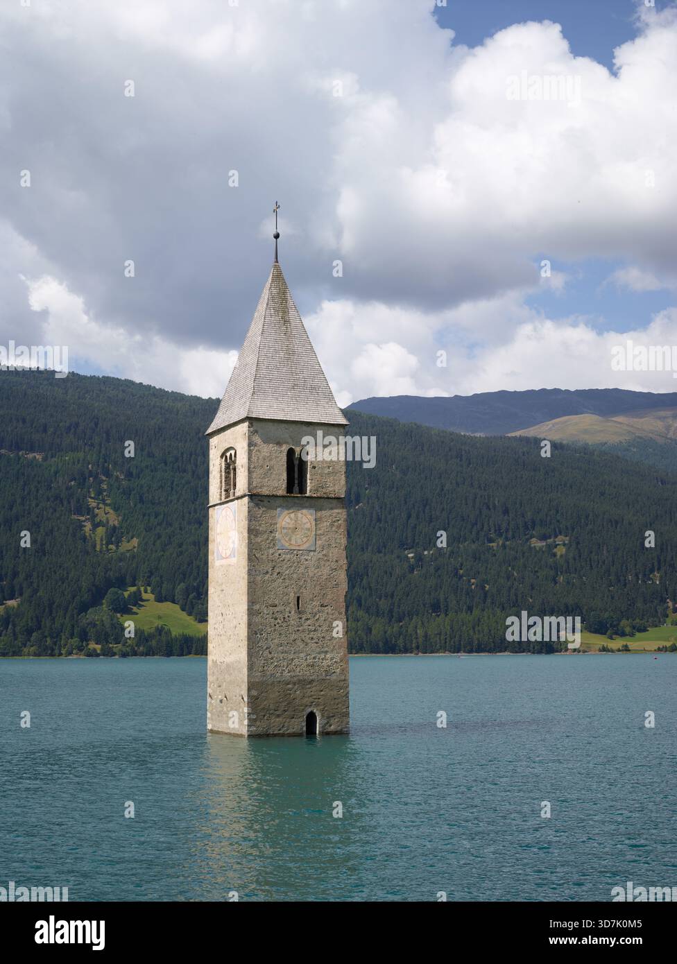 Italien, Bozen, Reschensee, verschlungener Kirchturm, der aus den Gewässern des Sees, umgeben von Bergen, entspringt Stockfoto
