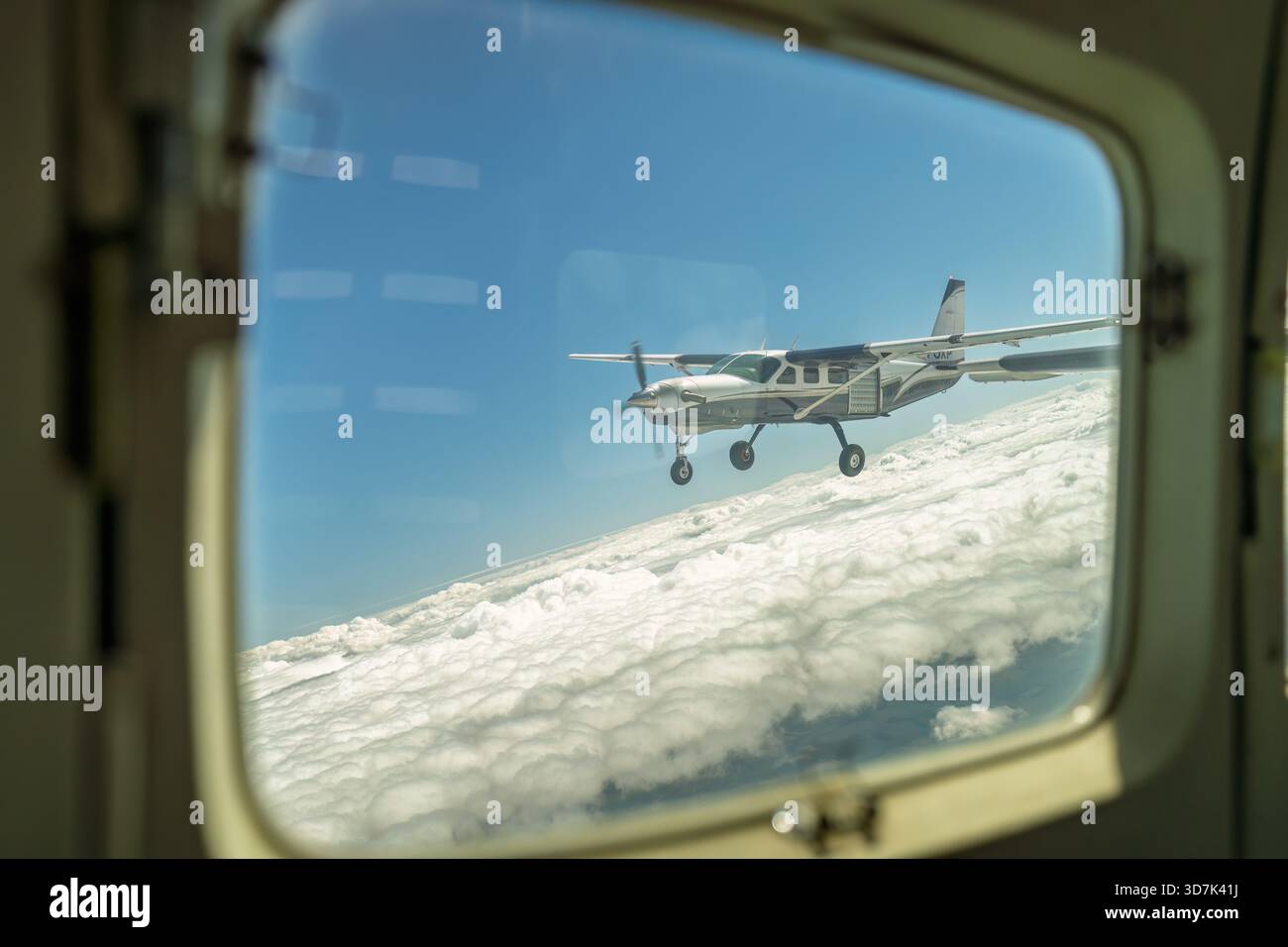 Ansicht des Flugzeugs im Flug über der Wolkenschicht aus einer anderen Ebene Stockfoto