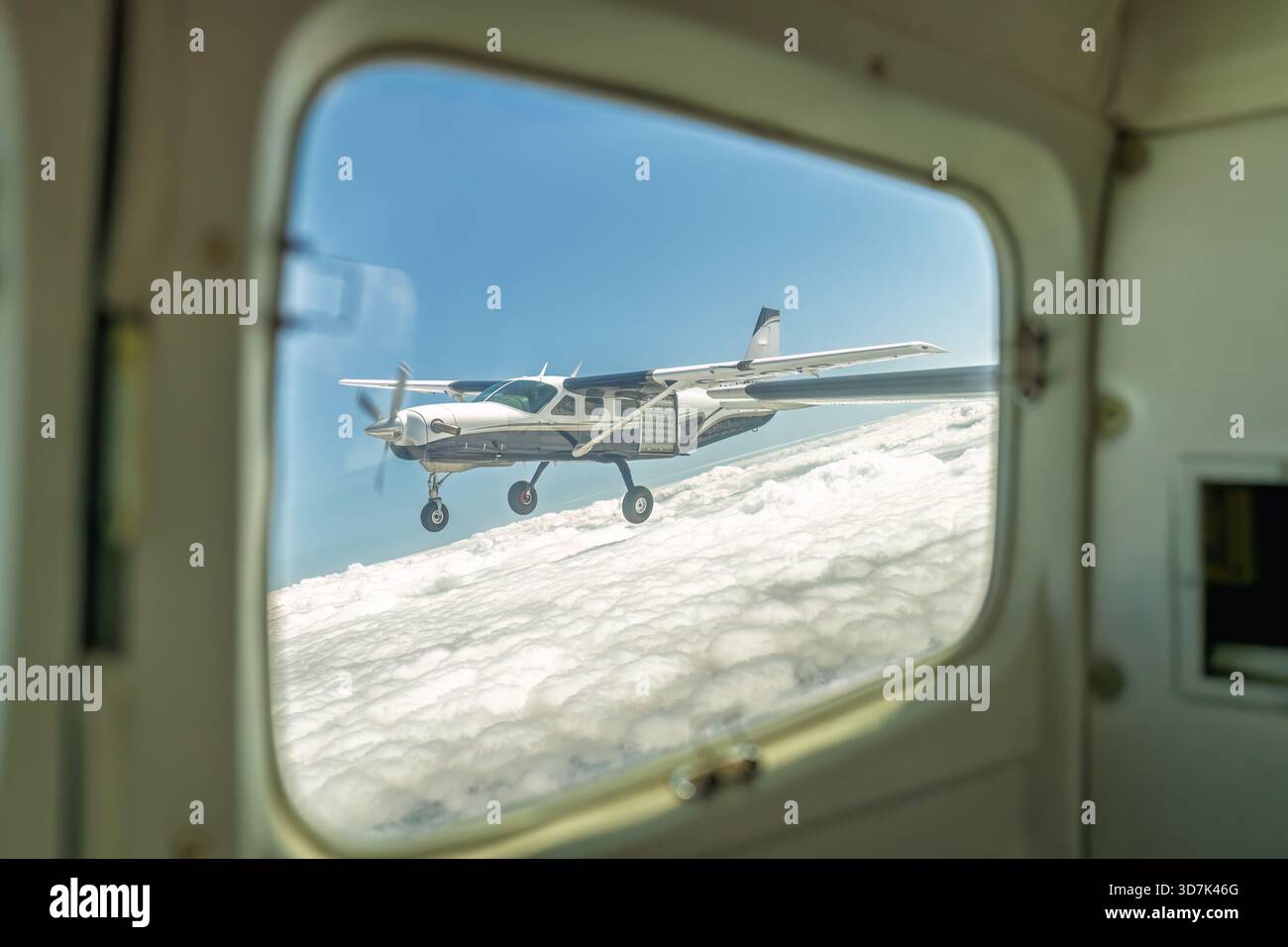 Ansicht des Flugzeugs im Flug über der Wolkenschicht aus einer anderen Ebene Stockfoto