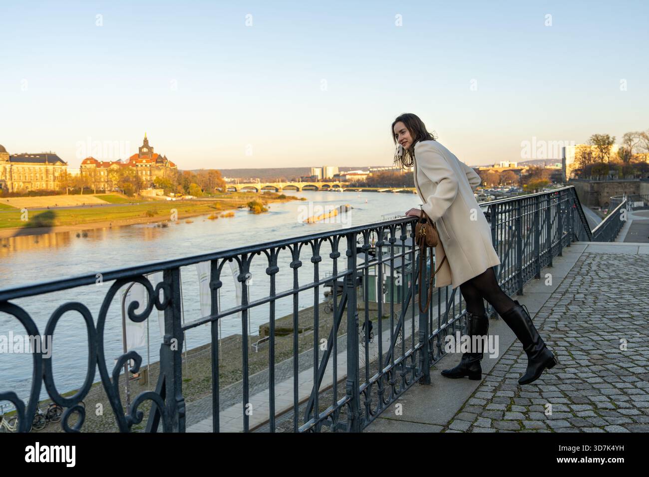 Charmante Frau im Mantel schlendert durch die historischen Straßen Dresdens, genießt Alleinreisen, Besichtigungen und Erkundung der Kultur dieser europäischen Stadt. Stockfoto