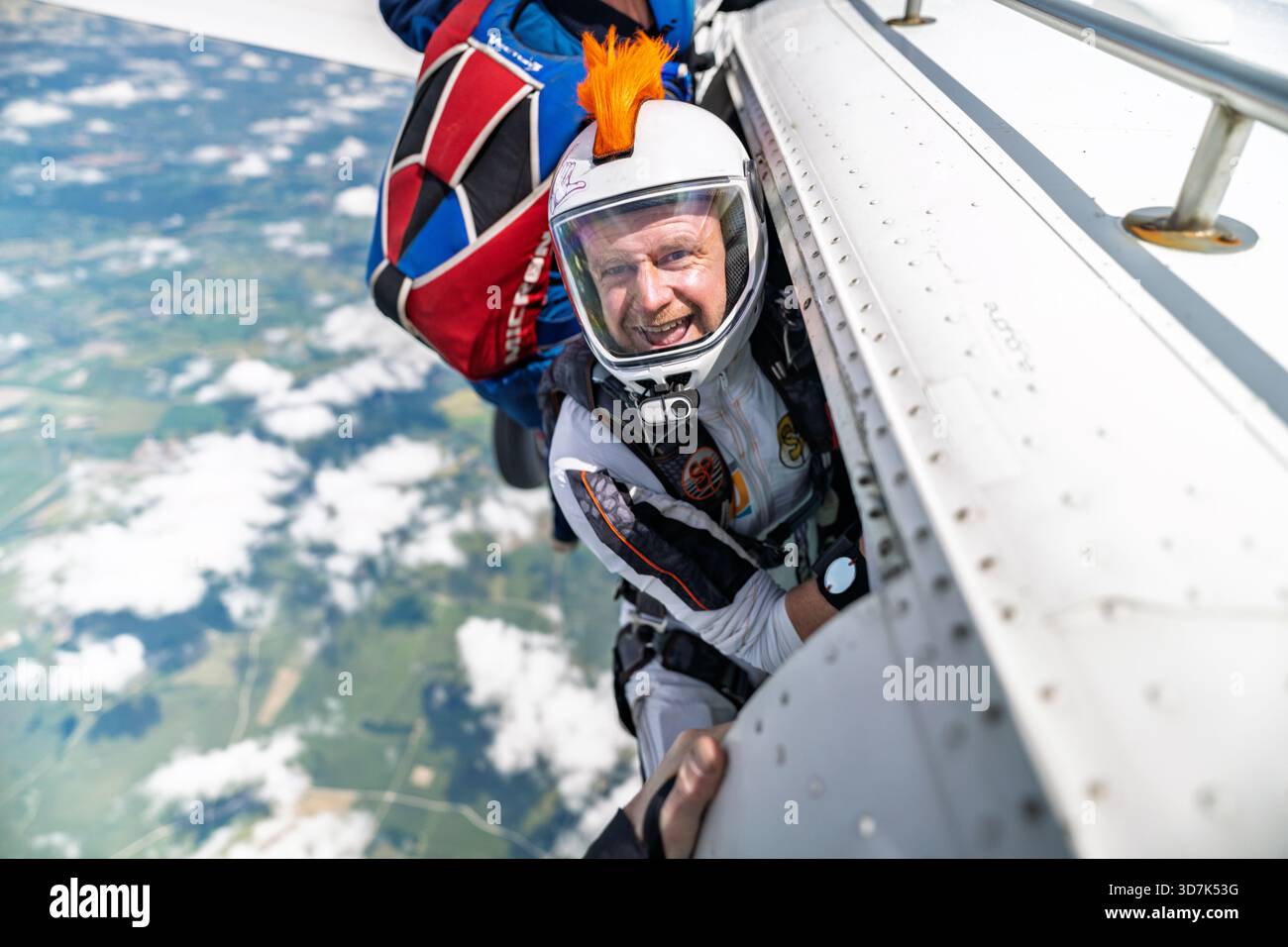 Fallschirmspringer mit orangefarbener mohawk-Geeks-Kamera am Ausgang Stockfoto