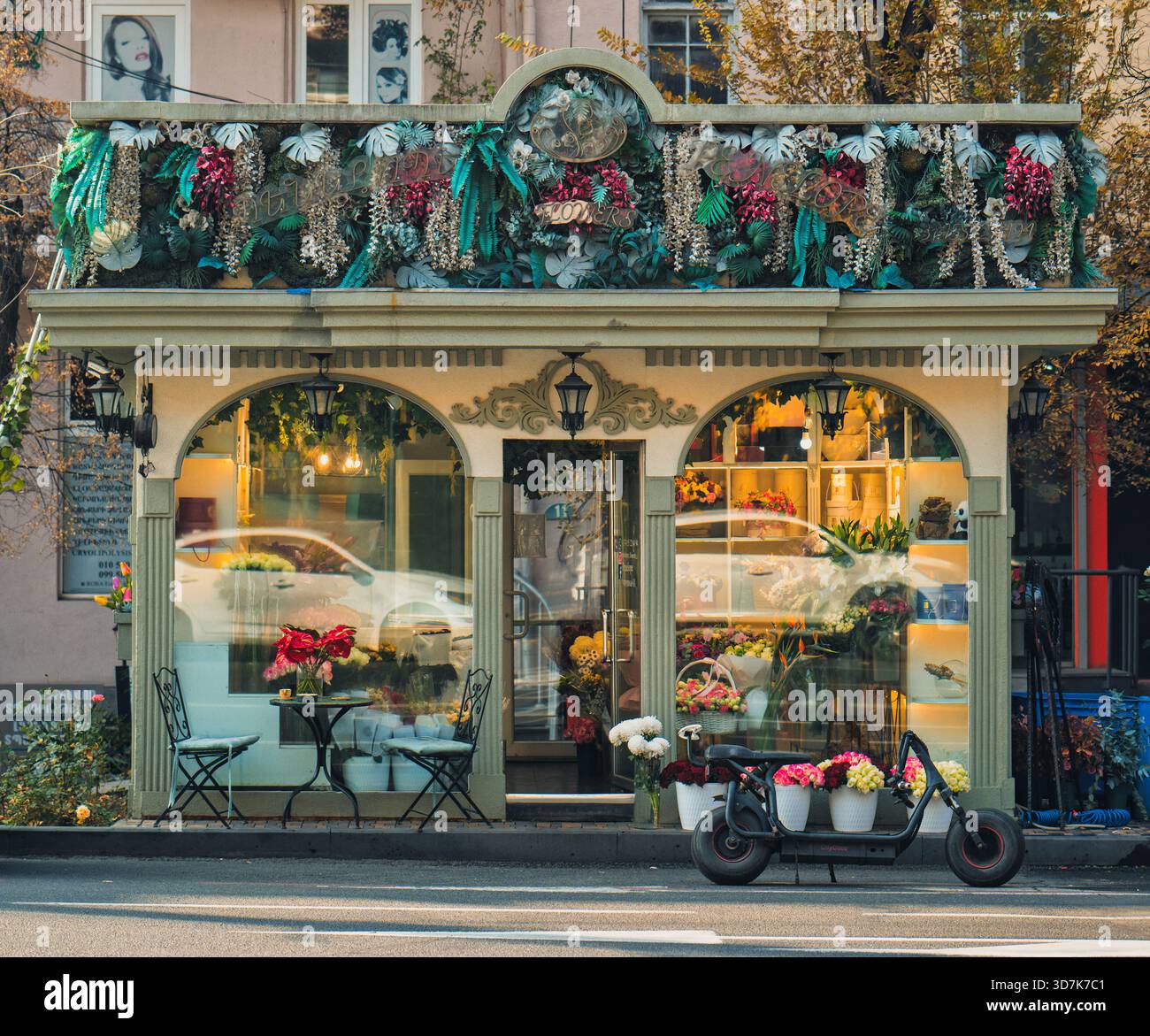 Jerewan Armenien 11.20.2025. Ein Blumenladen mit einem grünen Dach und einer Blumenausstellung. Ein Motorrad steht draußen. Der Laden ist geöffnet und einladend Stockfoto