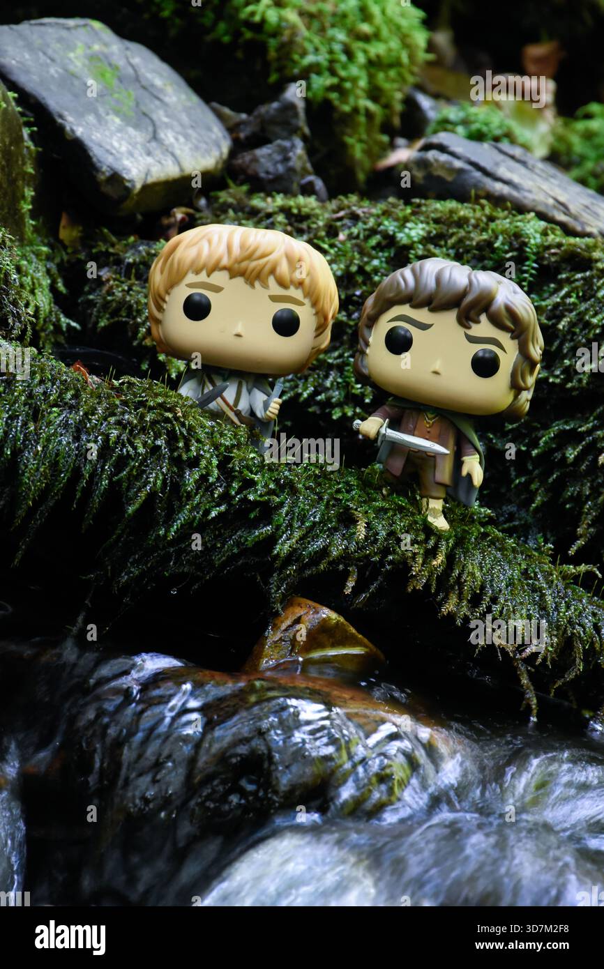 Funko Pop Actionfiguren der Hobbits Sam und Frodo aus dem Fantasy-Film der Herr der Ringe. Moosige, feuchte Steine, Bach. Stockfoto