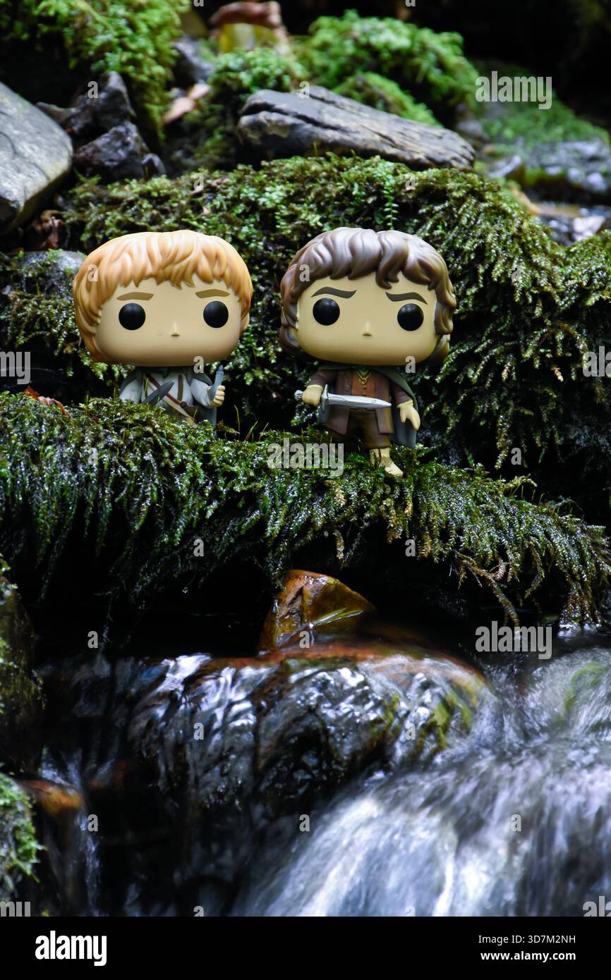 Funko Pop Actionfiguren der Hobbits Sam und Frodo aus dem Fantasy-Film der Herr der Ringe. Moosige, feuchte Steine, Bach. Stockfoto