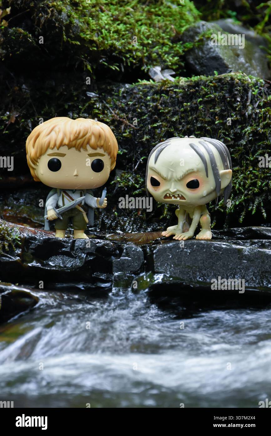 Funko Pop Actionfiguren von Sam und Gollum aus dem Film der Herr der Ringe. Moosige, feuchte Steine, schaumiges Flusswasser. Stockfoto