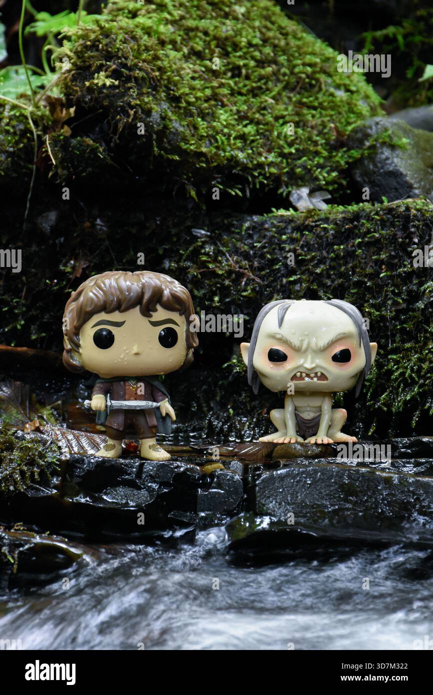 Funko Pop Actionfiguren von Frodo und Gollum aus dem Film der Herr der Ringe. Moosige, feuchte Steine, schaumiges Flusswasser. Stockfoto