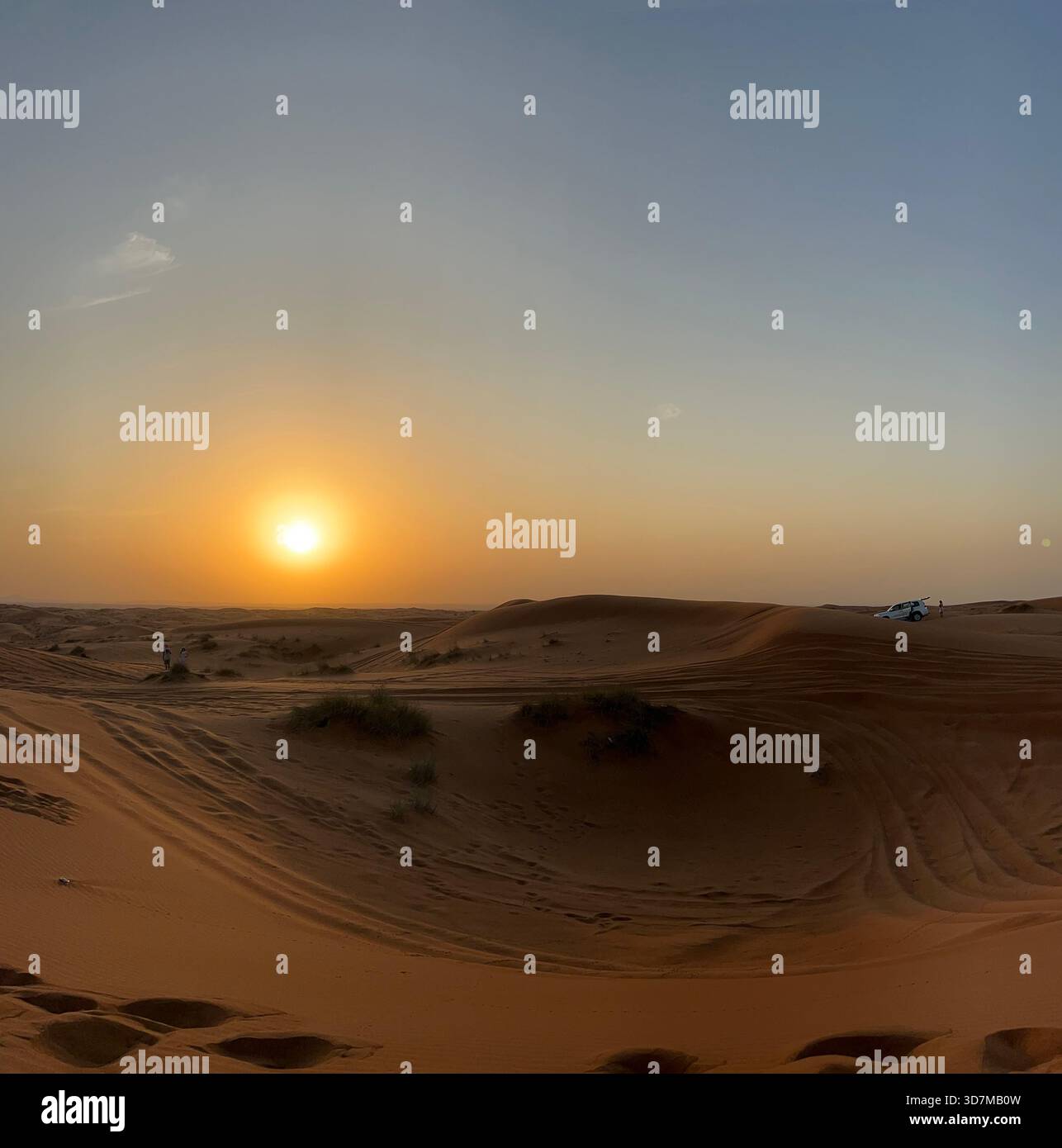 Goldener Sonnenuntergang über sanften Sanddünen in einer Wüstenlandschaft mit warmem Licht - Smartphone-aufgenommenes Stockfoto