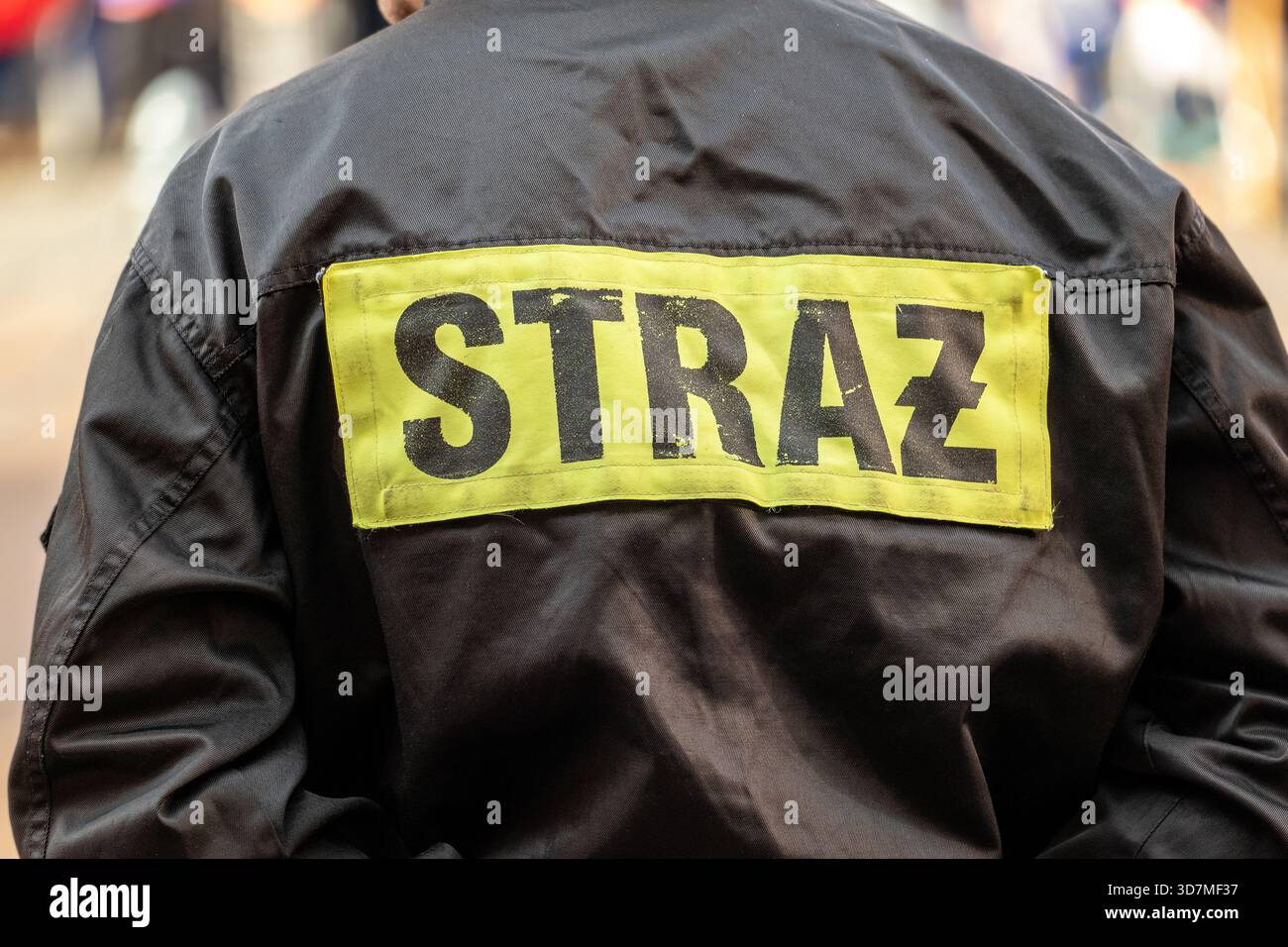 Polnische Feuerwehruniform Rücken mit dem Wort STRAZ reflektierendes Patch, Rettungsweste Nahaufnahme während der Reaktion, anonyme Feuerwehr Stockfoto