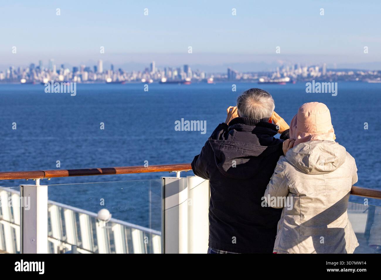 Ein Paar auf einem Kreuzfahrtschiff in Burrard Inlet mit Blick auf die Skyline von Vancouver - Vancouver, British Columbia, Kanada Stockfoto