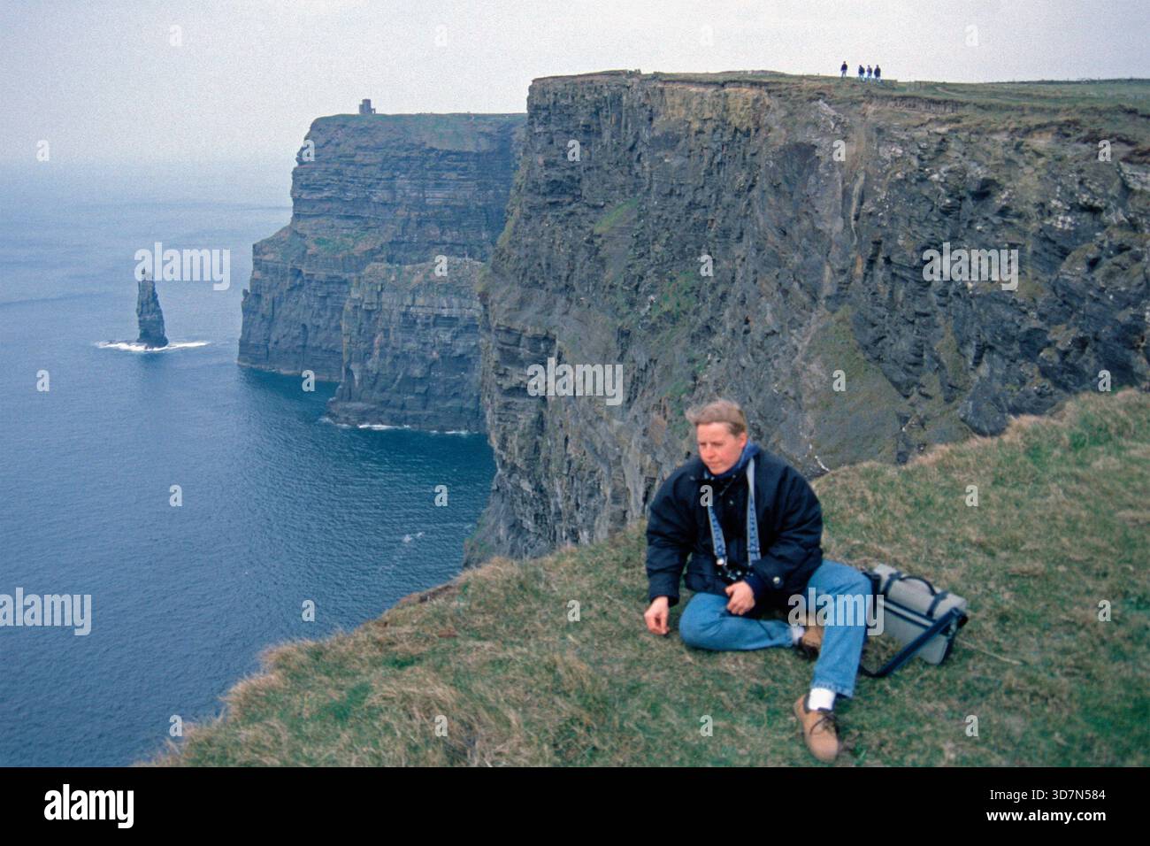 Junge Frau, die Fotos am Rande der Klippen macht, es gab noch keinen Zaun, Cliffs of Moher, County Clare, Republik Irland, April 1996 Stockfoto
