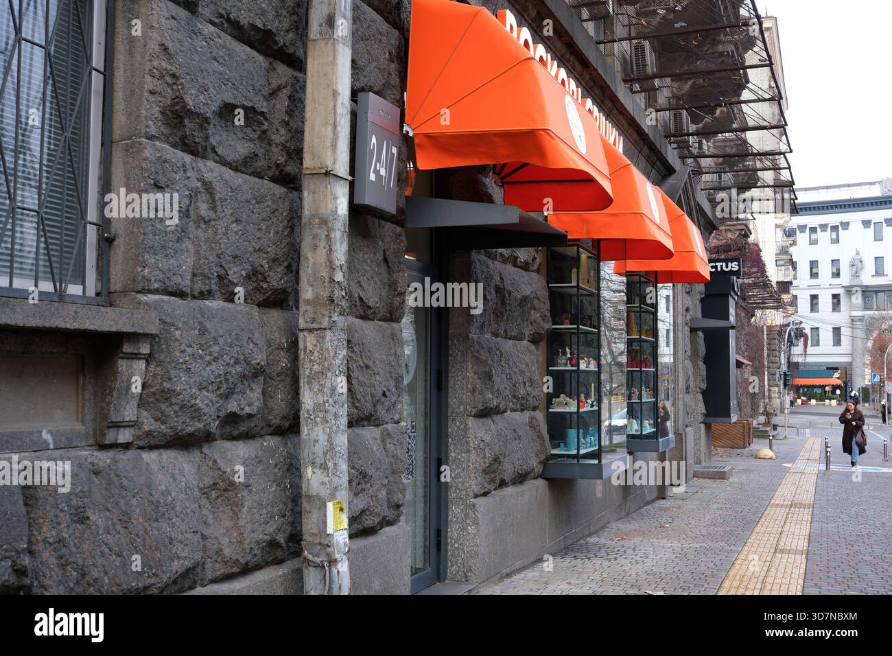 Farbenfrohe Markisen schmücken eine lebhafte Straße und laden Passanten ein, die Geschäfte in der Nähe zu erkunden. Kiew, Ukraine. November 2025. Stockfoto