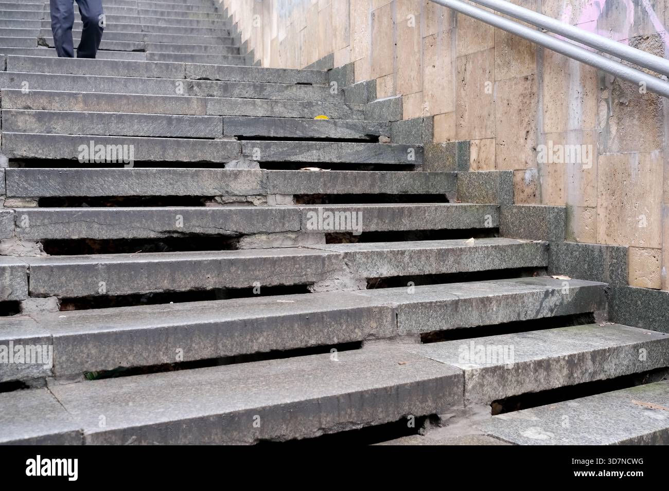 Alte Betonstufen zeigen Anzeichen von Verschleiß, wenn eine Person aufsteigt und die Geschichte enthüllt. Stockfoto