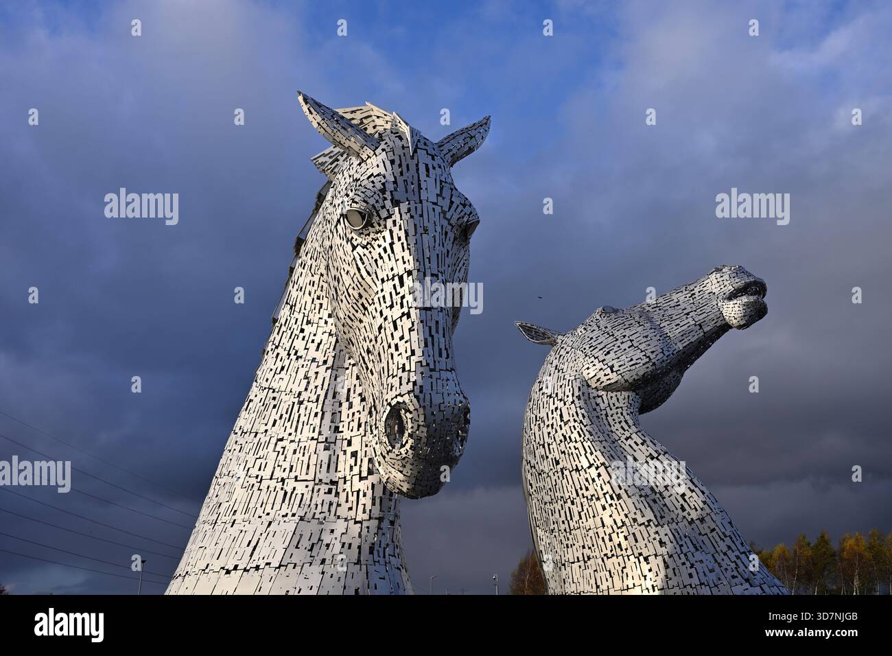 The Kelpies, ein öffentliches Stahlkunstwerk von zwei riesigen Pferdeköpfen von Andy Scott im Helix Park, im Herbstabendlicht Schottland November Stockfoto