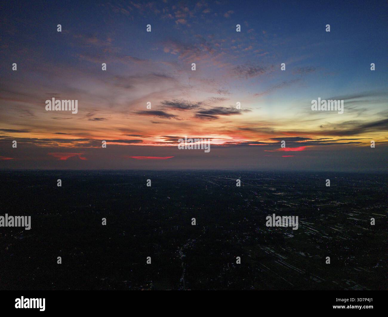 Luftaufnahme eines Sonnenaufgangs, der den Himmel in Orange, Rosa und Blau über der Landschaft malte, Klaten Regency, Zentral-Java, Indonesien. Stockfoto