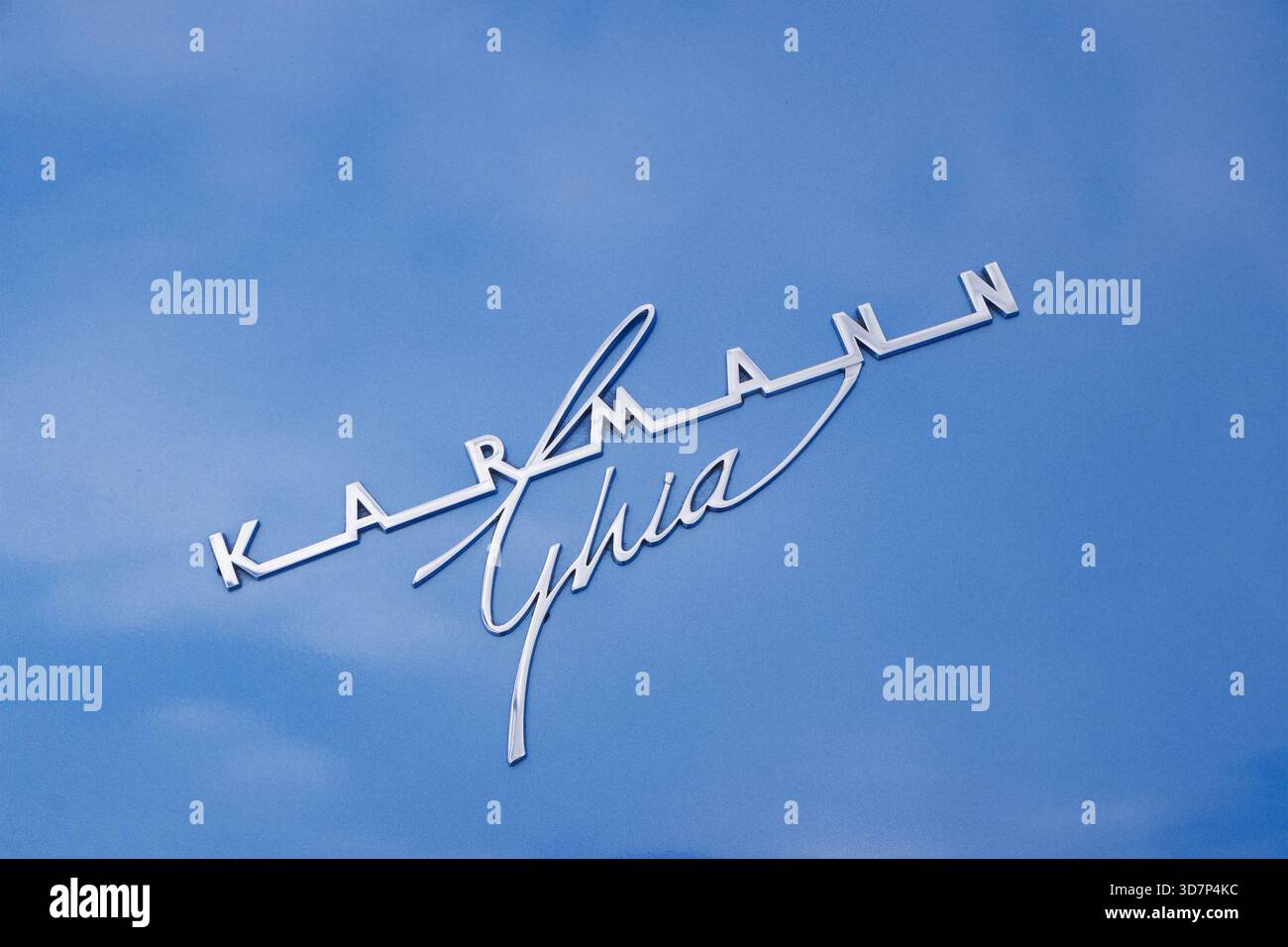 Nahaufnahme des Karmann-Ghia-Emblems an der Außenseite eines Volkswagen-Oldtimers auf einer blau lackierten Oberfläche Stockfoto