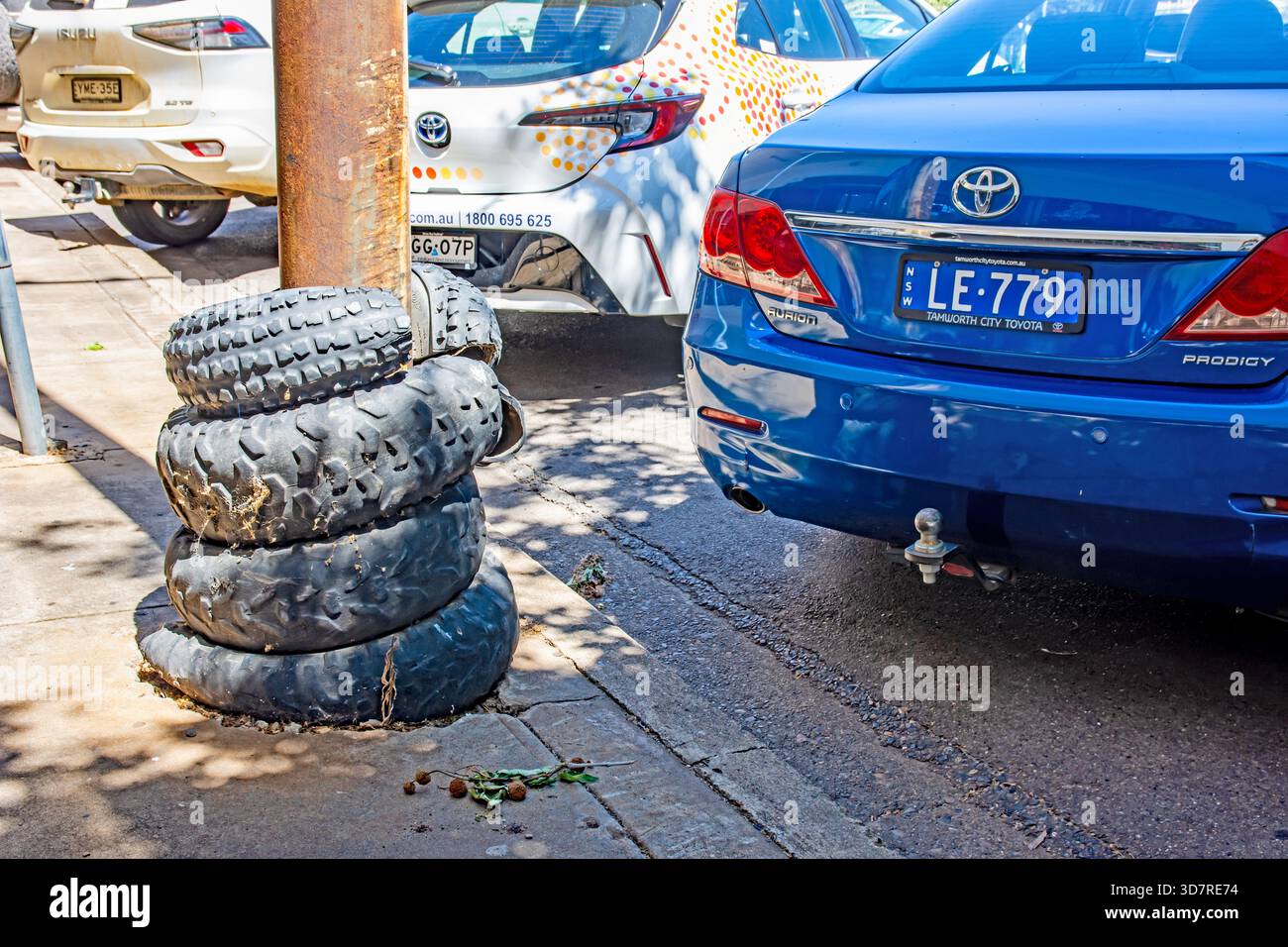 Alte LKW-Reifen, die um einen Stromanschluss gewickelt sind, um Rückwärtsparken vor Schäden zu schützen. Stockfoto